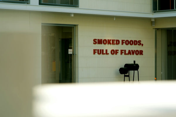 a sign on the side of a building that says smoked foods, full of flavor