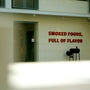 a sign on the side of a building that says smoked foods, full of flavor